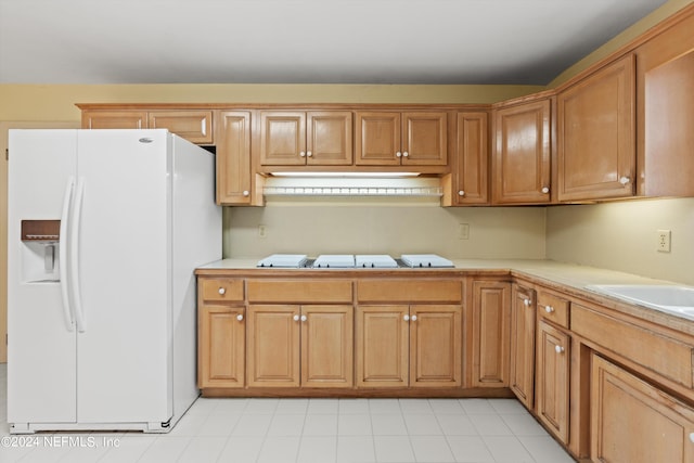 kitchen with stovetop and white refrigerator with ice dispenser