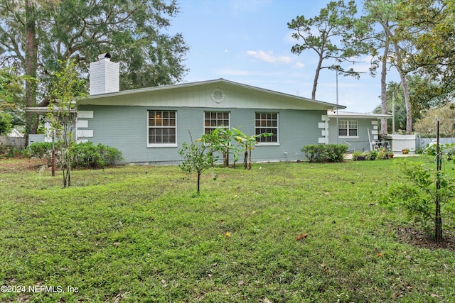 rear view of house featuring a lawn