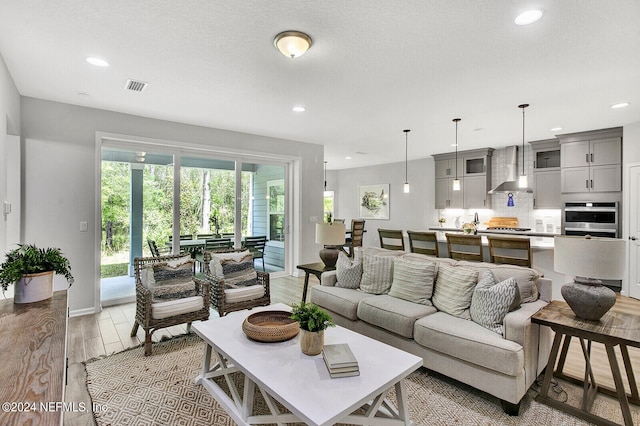 living room featuring light hardwood / wood-style flooring and a textured ceiling