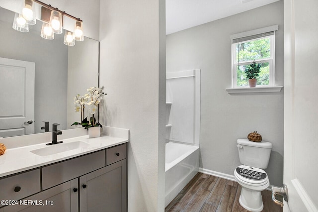 full bathroom with shower / washtub combination, wood-type flooring, vanity, and toilet