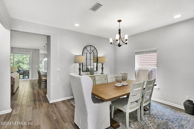 dining space with a notable chandelier and dark hardwood / wood-style floors