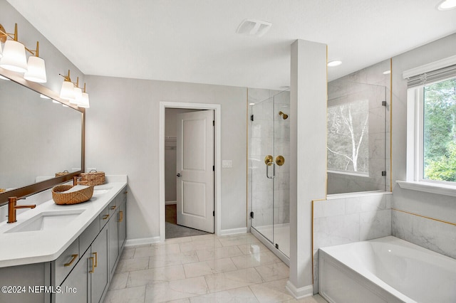 bathroom featuring vanity, separate shower and tub, and a healthy amount of sunlight