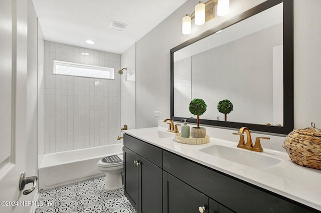 full bathroom with vanity, tiled shower / bath, and toilet