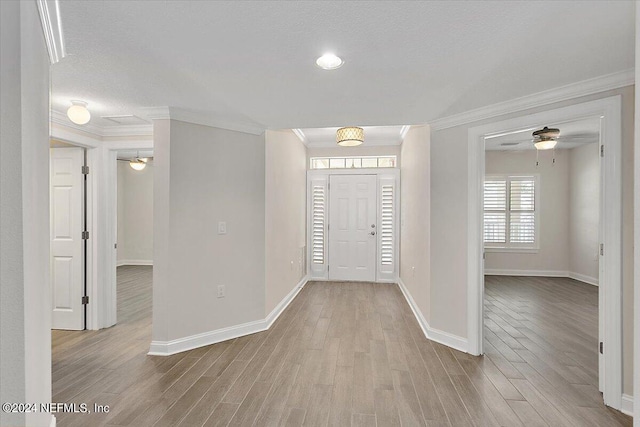 entryway with ornamental molding, light wood-type flooring, a textured ceiling, and ceiling fan