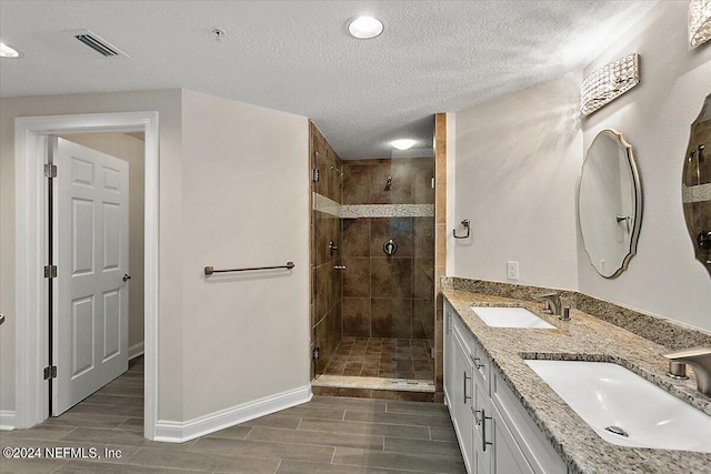 bathroom featuring vanity, walk in shower, and a textured ceiling