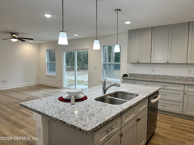 kitchen with gray cabinetry, sink, ceiling fan, light wood-type flooring, and an island with sink