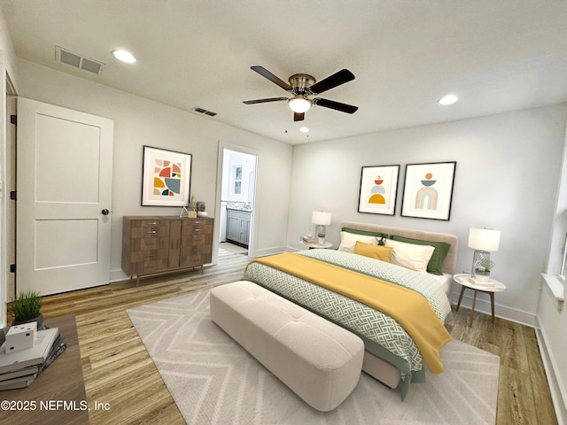 bedroom with wood-type flooring, ensuite bath, and ceiling fan