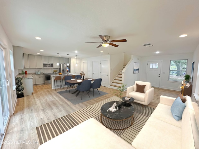 living room featuring ceiling fan and light hardwood / wood-style floors