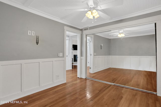 unfurnished room with wood-type flooring, ornamental molding, and ceiling fan