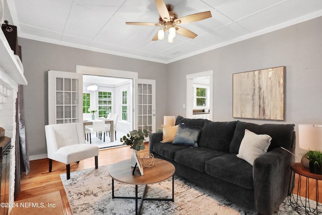 living room featuring ceiling fan, ornamental molding, hardwood / wood-style floors, and a healthy amount of sunlight