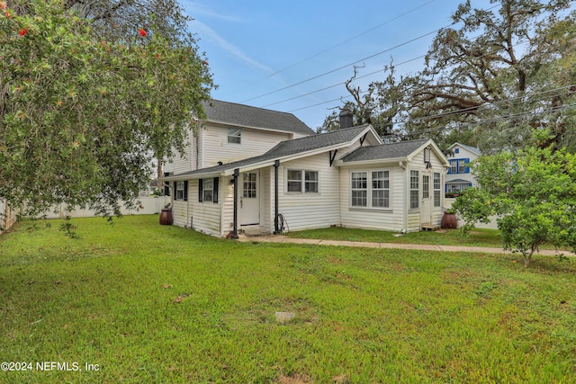 rear view of property featuring a yard