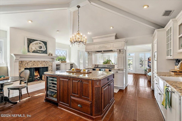 kitchen with dark wood-type flooring, a center island, and a healthy amount of sunlight