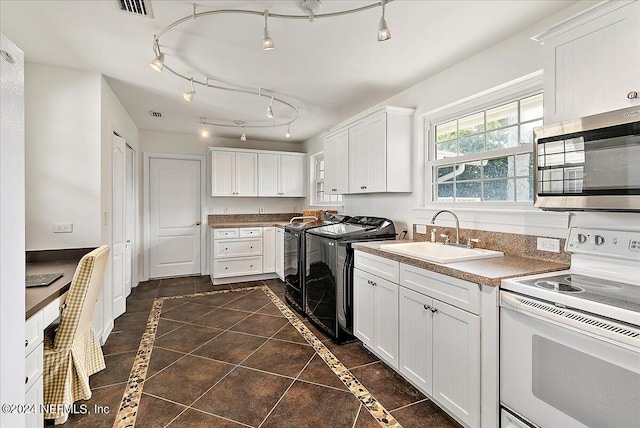 kitchen featuring white electric range oven, sink, washing machine and clothes dryer, and white cabinetry