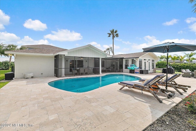 view of swimming pool with a patio, a sunroom, and french doors