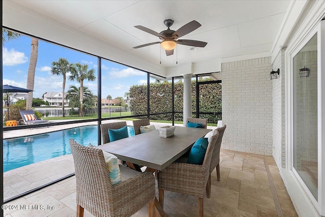 sunroom with decorative columns and ceiling fan