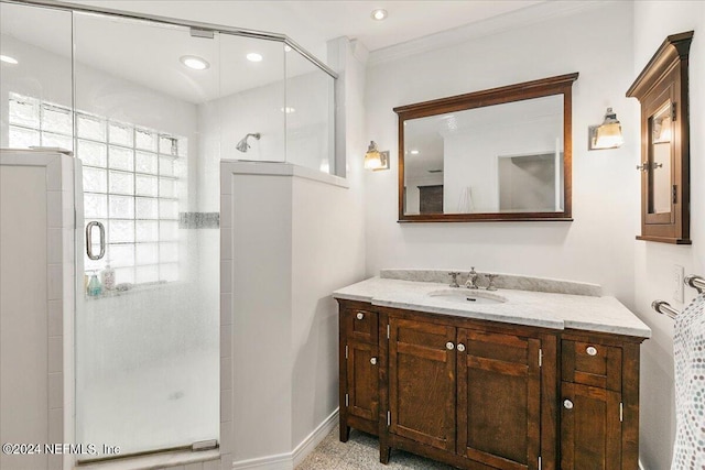 bathroom with vanity, a shower with shower door, and crown molding