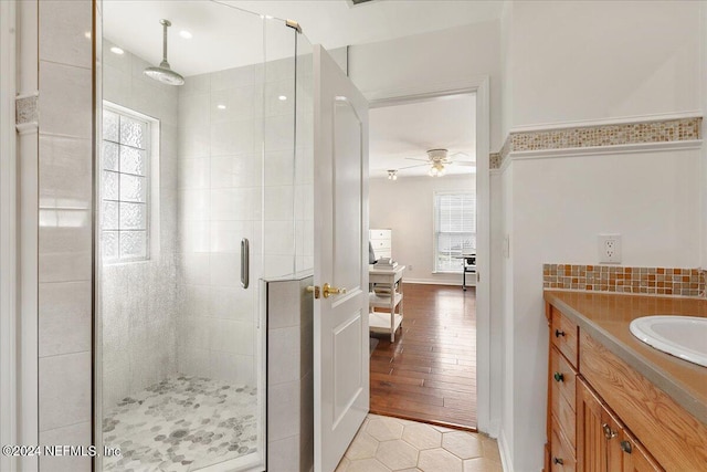 bathroom featuring vanity, hardwood / wood-style floors, ceiling fan, and an enclosed shower