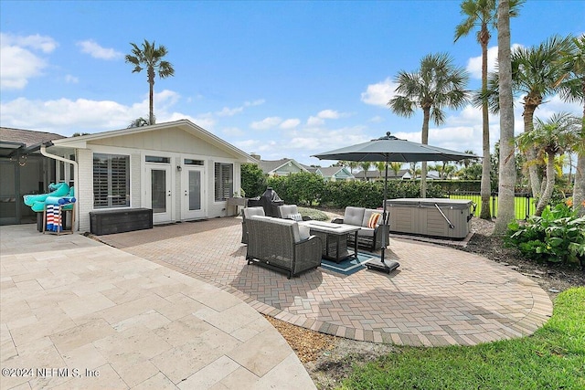 view of patio featuring a hot tub, outdoor lounge area, and french doors