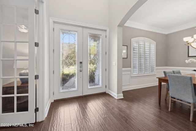 foyer featuring ornamental molding, french doors, dark hardwood / wood-style floors, and a chandelier