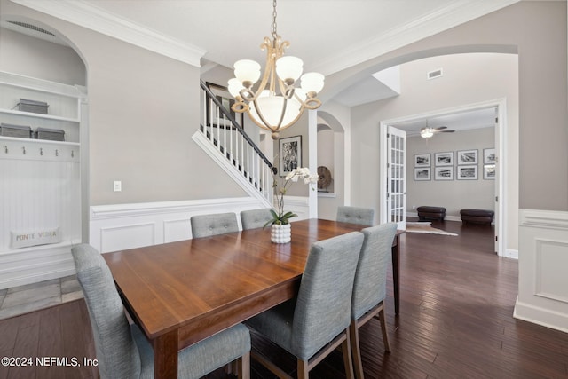 dining space featuring dark wood-type flooring, crown molding, and ceiling fan with notable chandelier