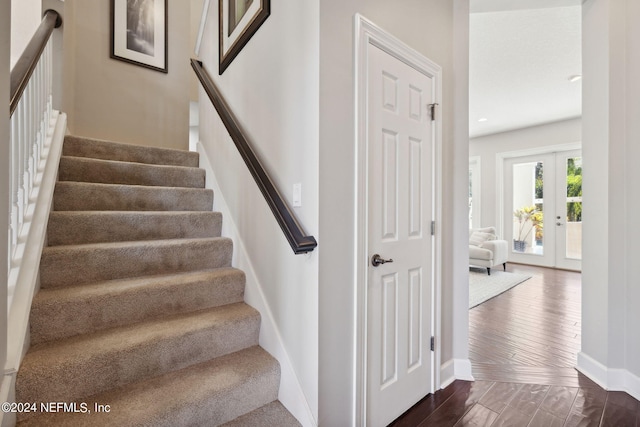 stairs featuring french doors and hardwood / wood-style flooring