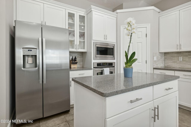 kitchen featuring white cabinets, stainless steel appliances, and backsplash