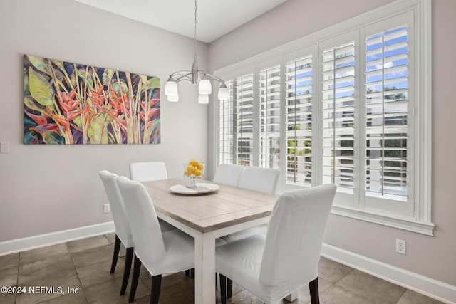 dining area featuring dark tile patterned flooring and a notable chandelier