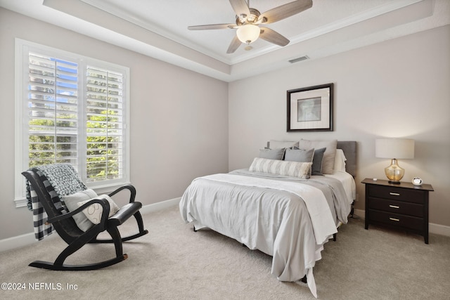 carpeted bedroom featuring ceiling fan, ornamental molding, and a tray ceiling