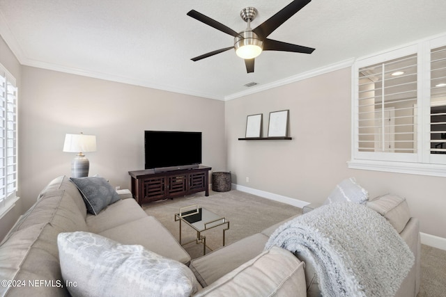 carpeted living room featuring a wealth of natural light, crown molding, and ceiling fan