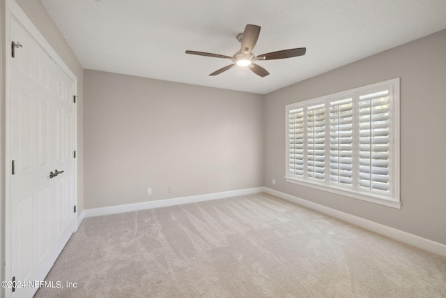 unfurnished bedroom with a closet, light carpet, and ceiling fan