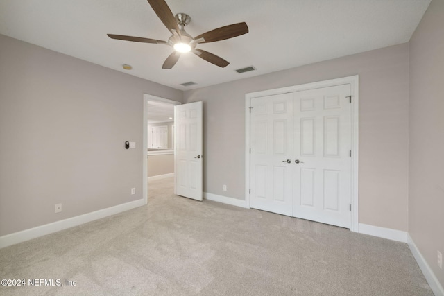 unfurnished bedroom featuring a closet, ceiling fan, and light carpet