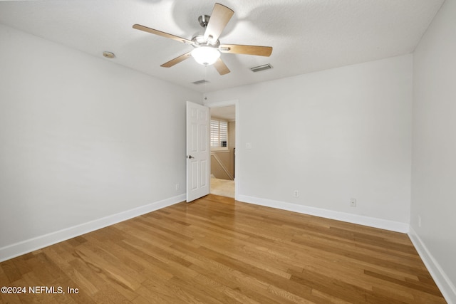 spare room featuring a textured ceiling, wood-type flooring, and ceiling fan