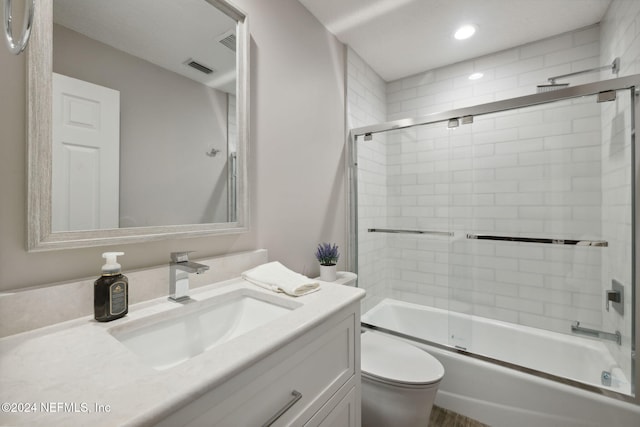 full bathroom with vanity, combined bath / shower with glass door, and toilet