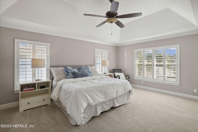 carpeted bedroom featuring a textured ceiling, multiple windows, and ceiling fan