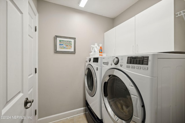 laundry room with cabinets, washer and dryer, and light tile patterned floors