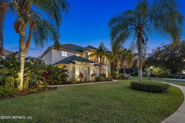 mediterranean / spanish home featuring a lawn