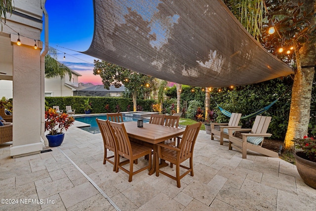 patio terrace at dusk featuring a fenced in pool