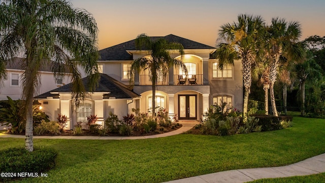 mediterranean / spanish-style home featuring a yard and a balcony