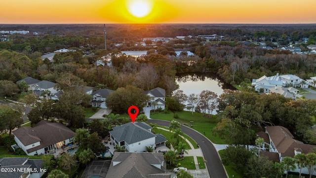 aerial view at dusk featuring a water view