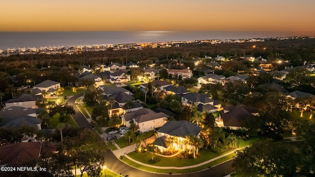 aerial view at dusk featuring a water view