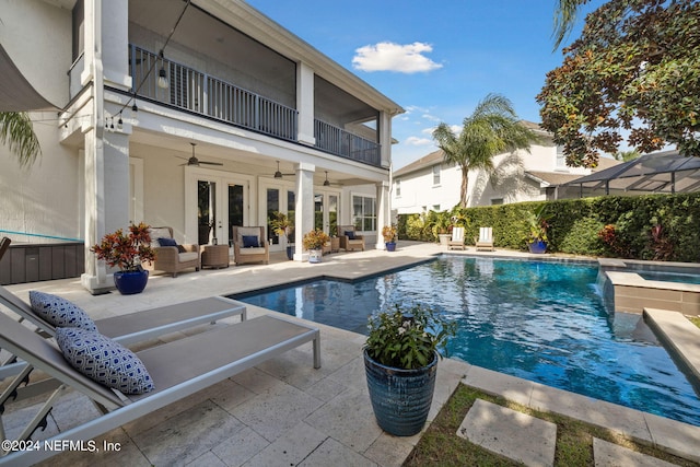 view of swimming pool with a patio area, french doors, a lanai, an outdoor hangout area, and ceiling fan