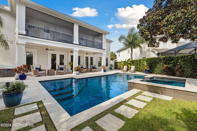 view of pool with a patio area, french doors, an in ground hot tub, and glass enclosure