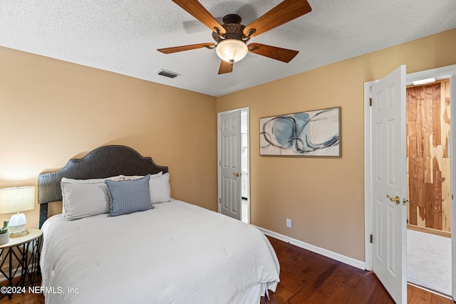 bedroom with ceiling fan, a textured ceiling, and dark hardwood / wood-style flooring