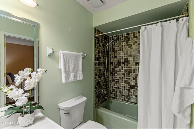 bathroom featuring shower / bath combo, a textured ceiling, and toilet