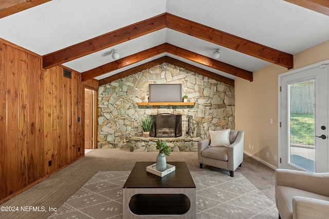 living room featuring vaulted ceiling with beams, wood walls, carpet, and a healthy amount of sunlight