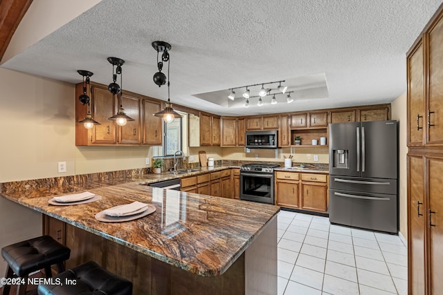 kitchen with stainless steel appliances, kitchen peninsula, decorative light fixtures, and a textured ceiling