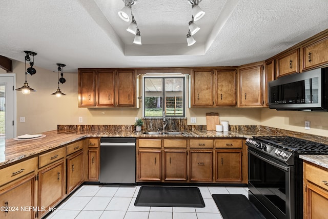 kitchen featuring stainless steel appliances, a textured ceiling, a tray ceiling, track lighting, and sink