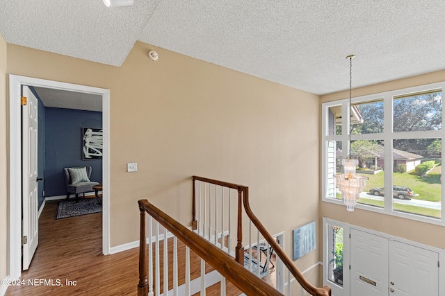 hall with a textured ceiling and hardwood / wood-style floors