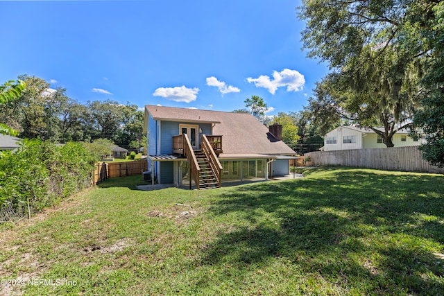 back of house featuring a lawn and a deck