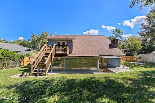 rear view of house featuring a wooden deck, a yard, and a patio